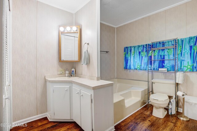 bathroom featuring wood-type flooring, a bathtub, vanity, ornamental molding, and toilet