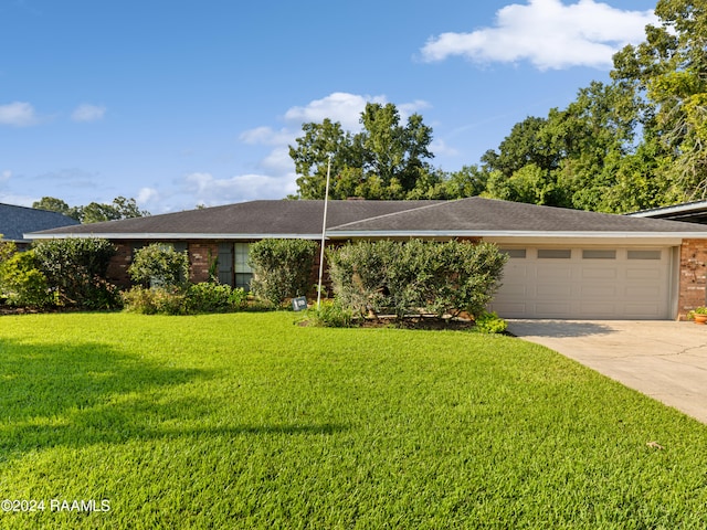 ranch-style house featuring a garage and a front lawn