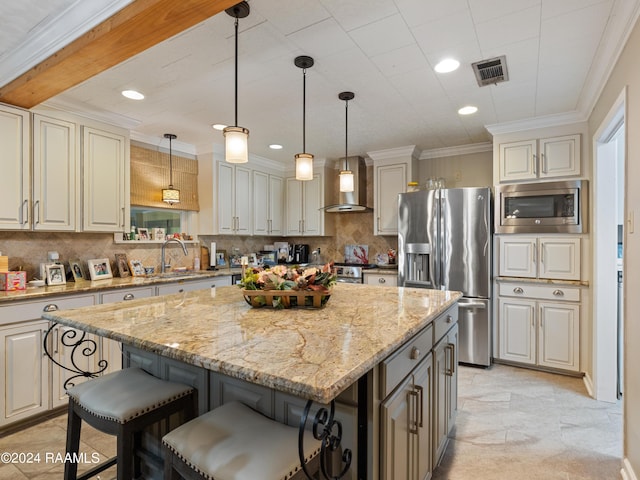 kitchen featuring sink, hanging light fixtures, a center island, stainless steel appliances, and wall chimney exhaust hood