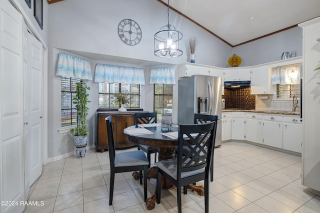 tiled dining room featuring high vaulted ceiling, a notable chandelier, crown molding, and sink