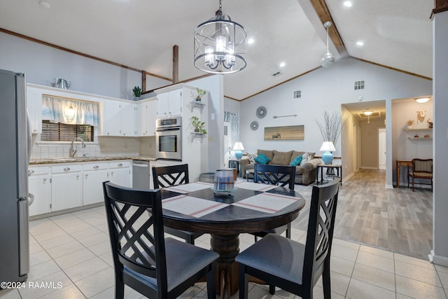 dining area with a chandelier, light hardwood / wood-style floors, beamed ceiling, sink, and high vaulted ceiling