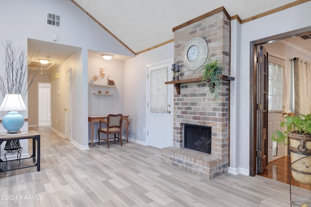 living room with light wood-type flooring, high vaulted ceiling, crown molding, and a brick fireplace