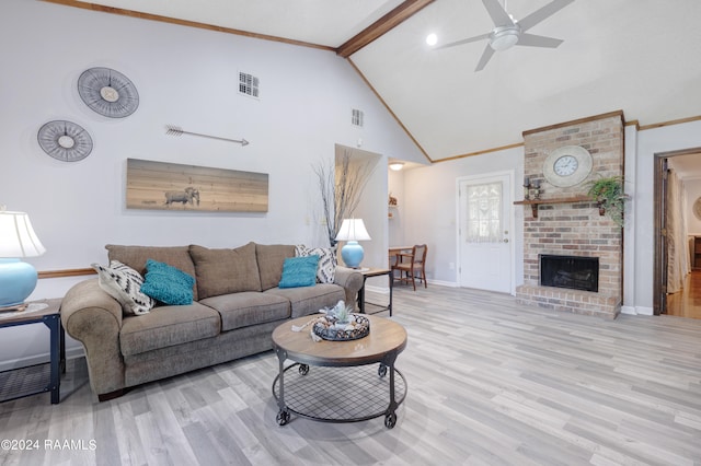 living room featuring a brick fireplace, light wood-type flooring, high vaulted ceiling, beamed ceiling, and ceiling fan