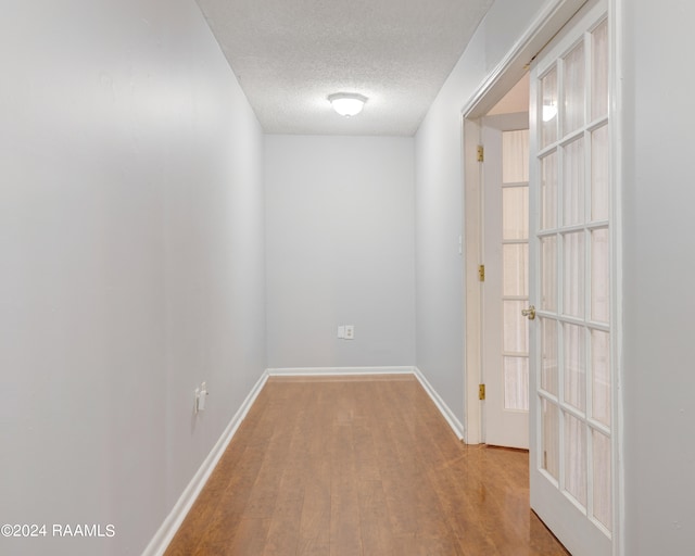 spare room featuring light wood-type flooring and a textured ceiling