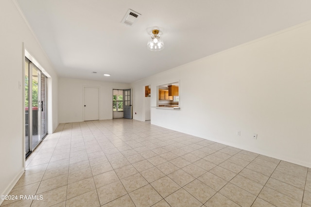 unfurnished living room with crown molding and light tile patterned floors