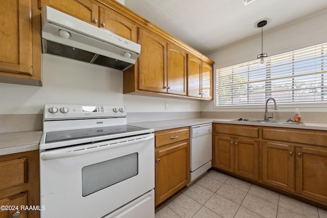 kitchen with hanging light fixtures, sink, white appliances, and light tile patterned flooring