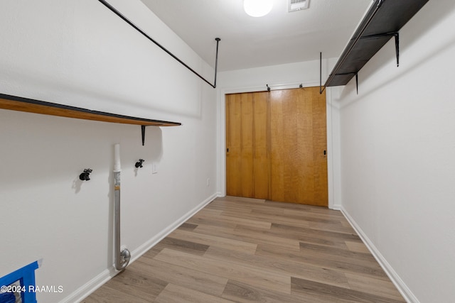 clothes washing area featuring light hardwood / wood-style flooring and washer hookup