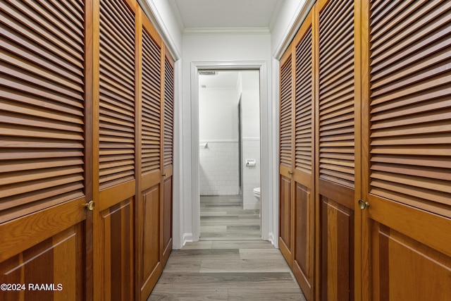 hallway with crown molding and light hardwood / wood-style floors