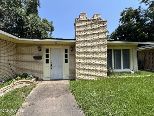 doorway to property featuring a yard