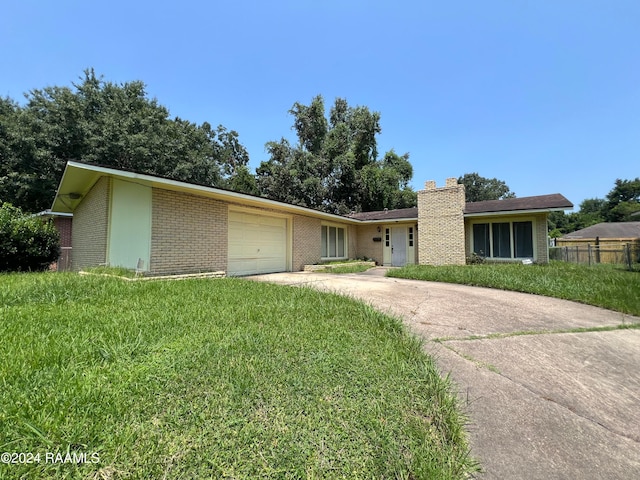 ranch-style home with a front lawn and a garage