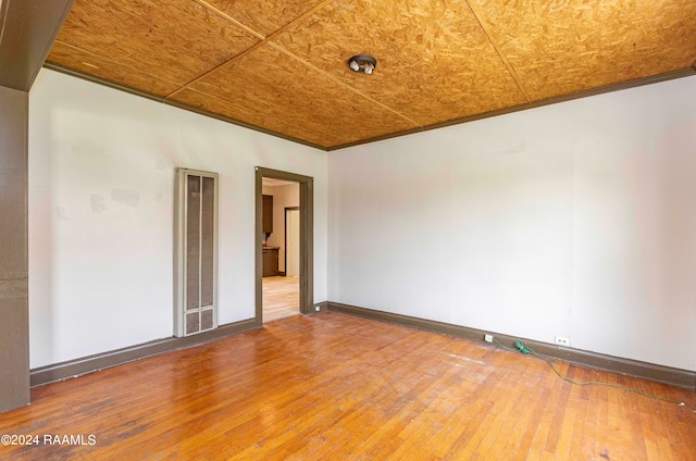 unfurnished room with wood-type flooring and ornamental molding