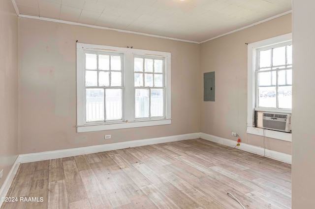 spare room with electric panel, crown molding, light wood-type flooring, and cooling unit