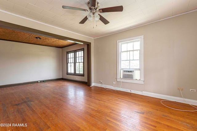 empty room featuring ceiling fan, hardwood / wood-style flooring, plenty of natural light, and cooling unit