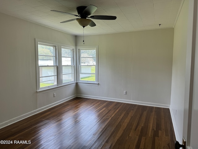 unfurnished room featuring dark wood-style floors, ceiling fan, crown molding, and baseboards