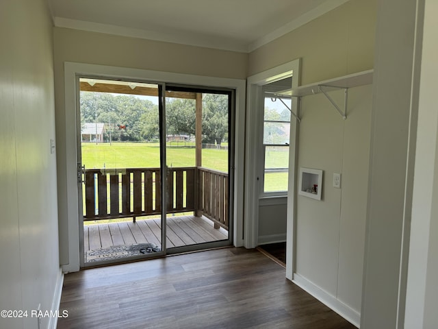 doorway featuring baseboards, ornamental molding, and wood finished floors