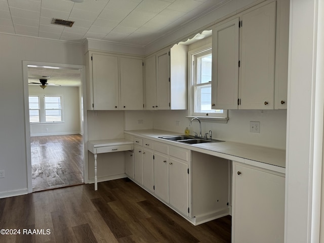 kitchen featuring dark wood-type flooring, a sink, visible vents, white cabinetry, and light countertops