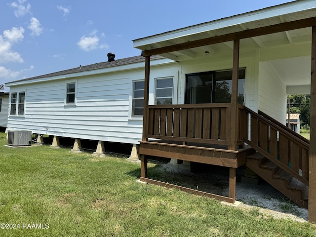 back of property with a yard, roof with shingles, and cooling unit