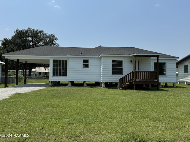 view of front of home with a front yard, roof with shingles, and driveway