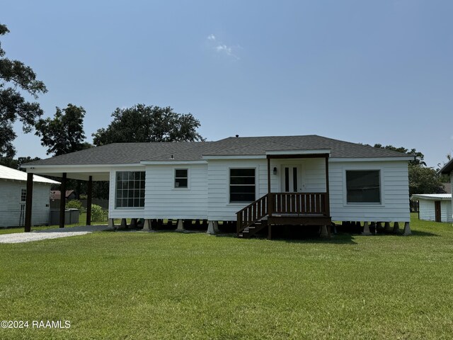 view of front of property with a front yard and a carport