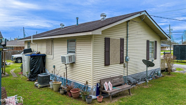 view of side of home featuring cooling unit, central AC unit, and a lawn