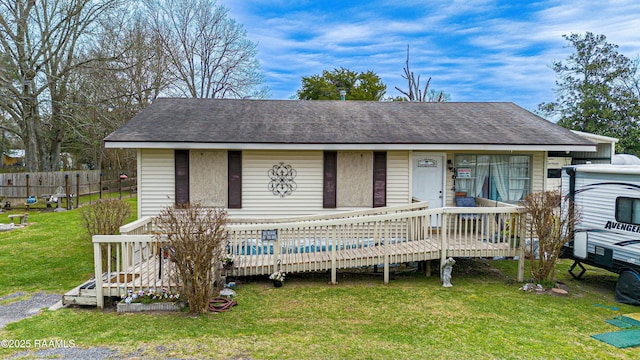 view of front of home featuring a covered pool and a front lawn