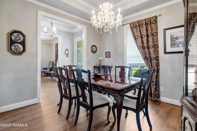 dining space with an inviting chandelier, plenty of natural light, light hardwood / wood-style flooring, and ornamental molding