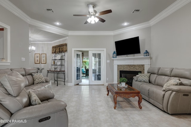 living room with crown molding, ceiling fan with notable chandelier, and light tile patterned floors