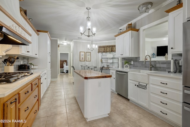 kitchen featuring white cabinetry, a center island, stainless steel appliances, and tasteful backsplash