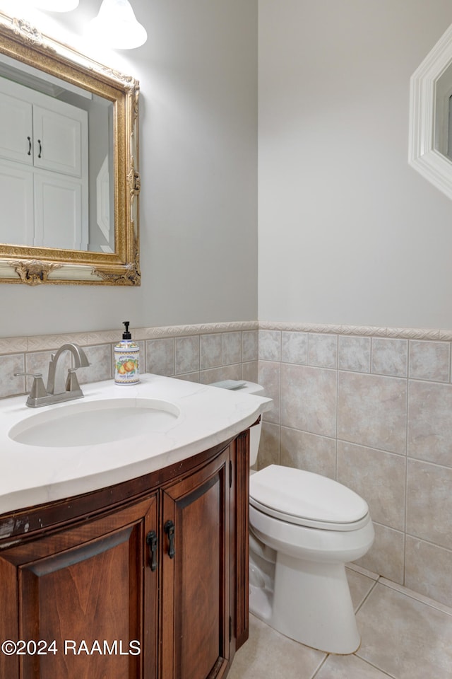 bathroom with vanity, toilet, tile patterned floors, and tile walls