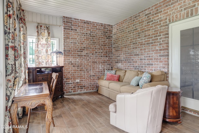 living room featuring brick wall and light wood-type flooring