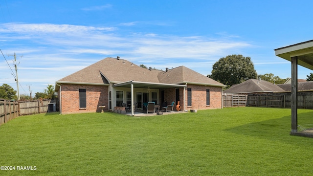 back of house with a patio area and a lawn