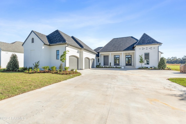 french country style house with a garage and a front lawn