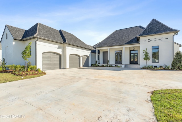 french country home with french doors and a garage