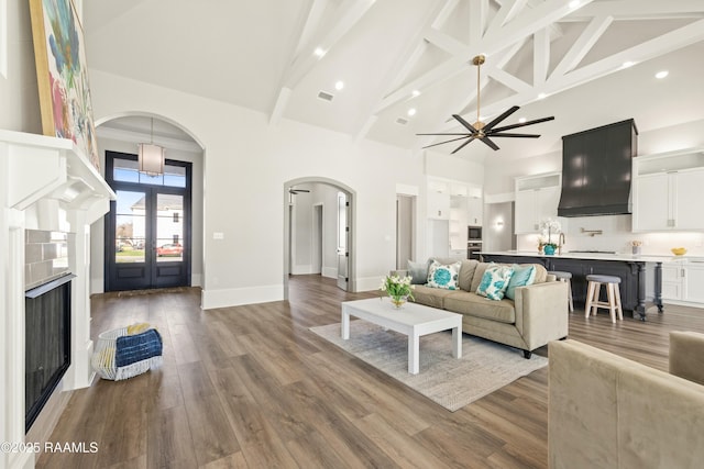 living room featuring beam ceiling, high vaulted ceiling, french doors, and hardwood / wood-style floors