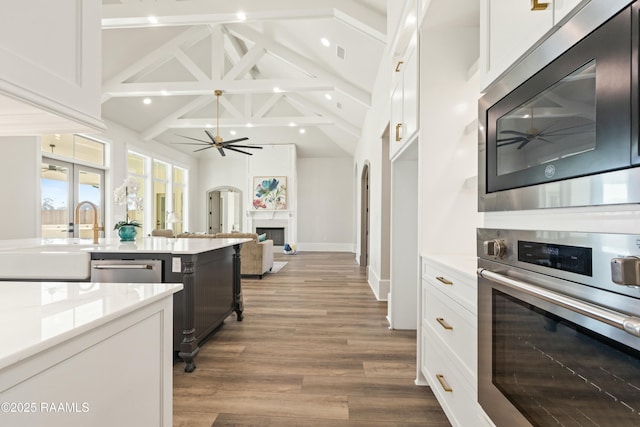 kitchen featuring stainless steel appliances, white cabinets, ceiling fan, high vaulted ceiling, and sink