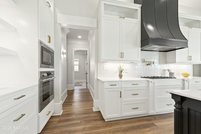 kitchen featuring appliances with stainless steel finishes, white cabinetry, and premium range hood