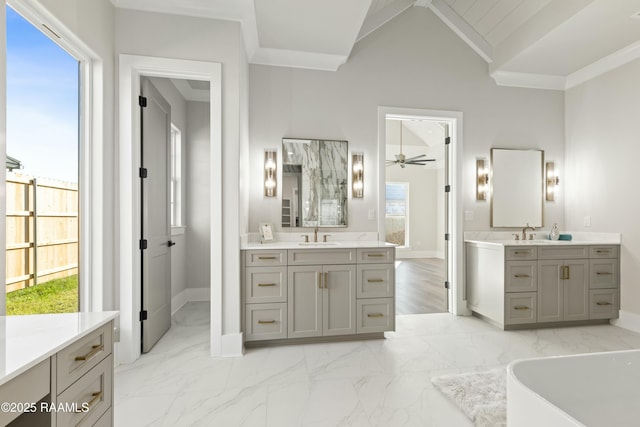 bathroom with a washtub, vaulted ceiling, crown molding, and vanity