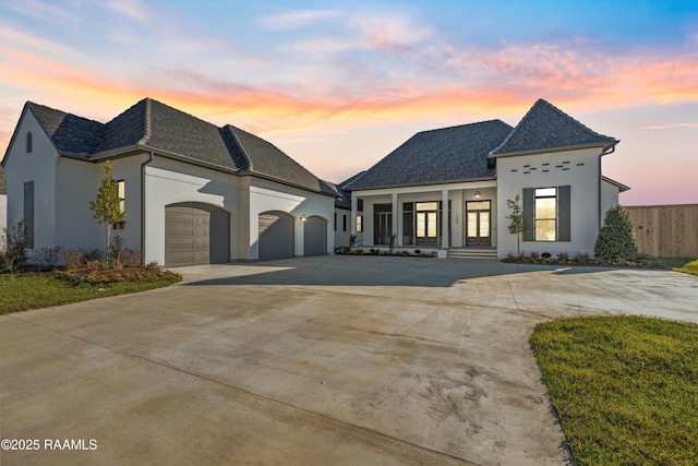 french country style house with a garage and a porch