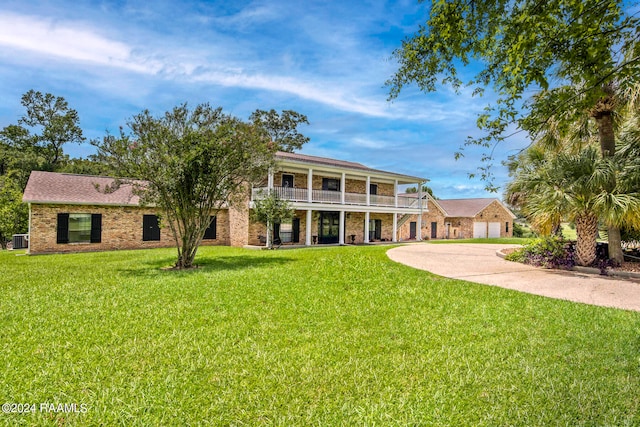 rear view of property with a lawn and a balcony