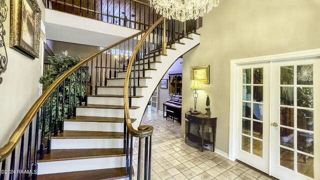 415 Fort Hamilton Dr, Opelousas, LA 70570 - stairs featuring an inviting chandelier, baseboards, a towering ceiling, tile patterned flooring, and french doors