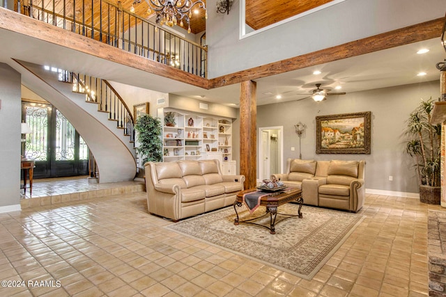 living room featuring french doors, ceiling fan with notable chandelier, a high ceiling, and light tile patterned floors