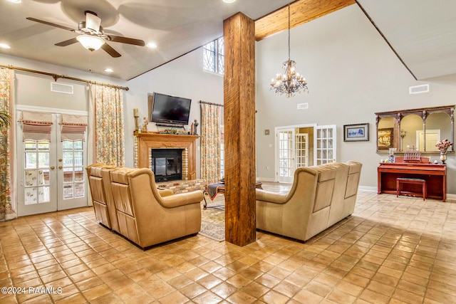 living room with light tile patterned floors, ceiling fan with notable chandelier, french doors, and a fireplace