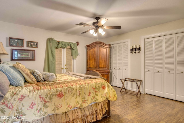 bedroom with ceiling fan, two closets, and wood-type flooring