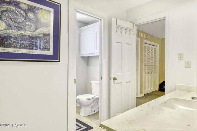 415 Fort Hamilton Dr, Opelousas, LA 70570 - bathroom featuring baseboards, wood finished floors, and toilet
