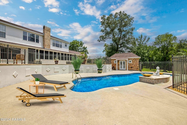 view of swimming pool with a patio and an outdoor structure