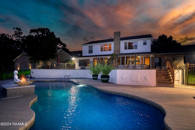 pool at dusk with a patio