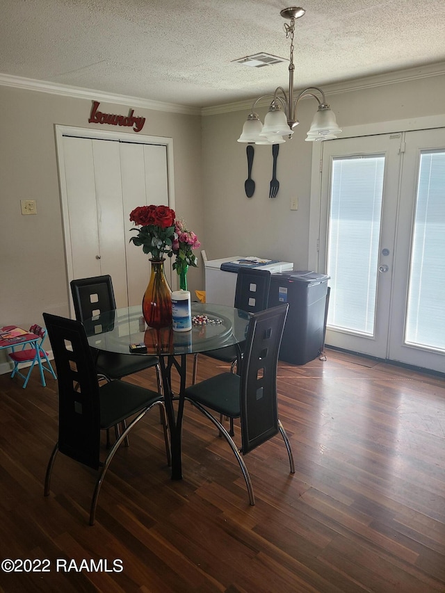 dining space with a textured ceiling, crown molding, hardwood / wood-style flooring, and french doors