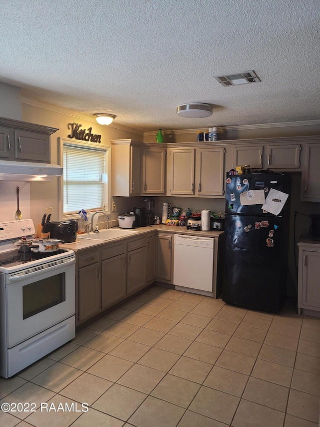 kitchen featuring a textured ceiling, white appliances, light tile patterned flooring, and sink