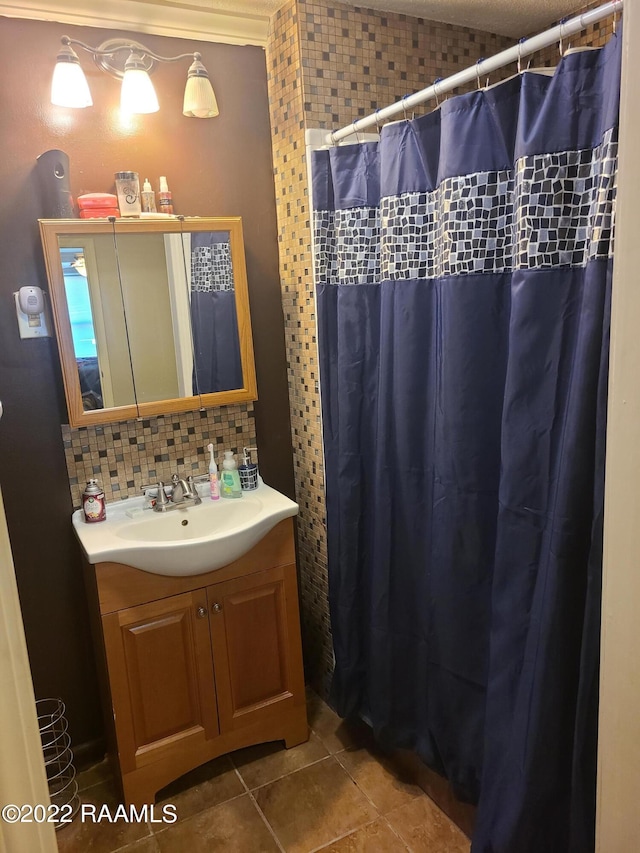 bathroom with backsplash, crown molding, tile patterned floors, and vanity