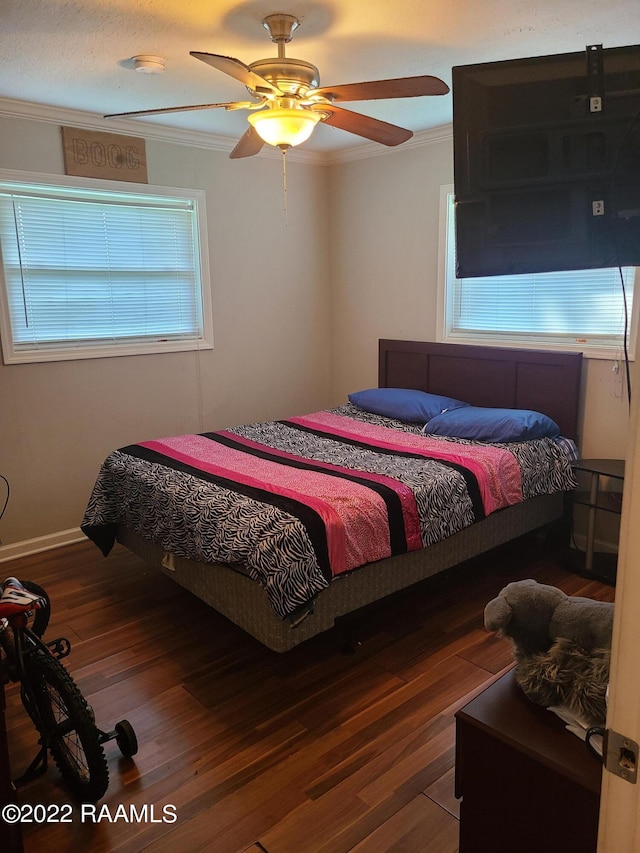 bedroom with ceiling fan, crown molding, multiple windows, and wood-type flooring